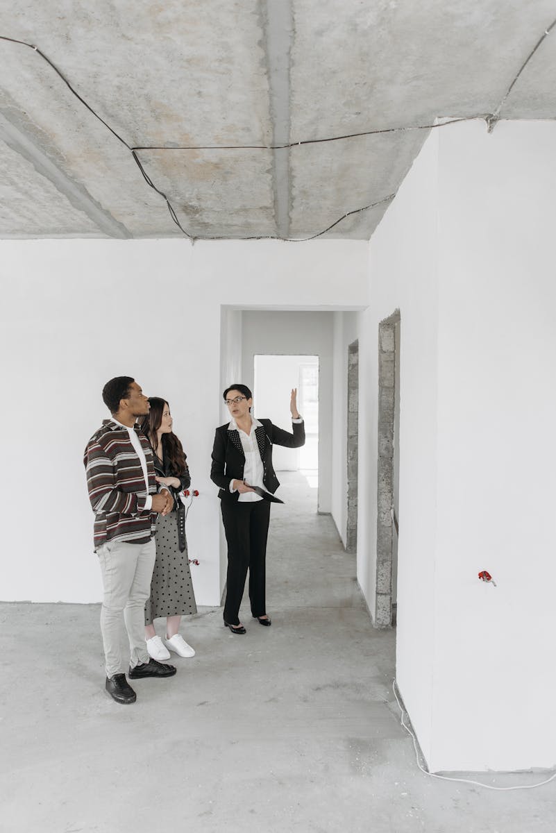 A real estate agent shows an empty property to potential buyers in a modern style.